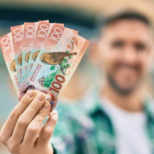 Man holding cash after selling his car in Tauranga