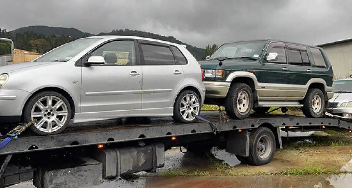 Towing Two Scrap Cars – Cash For Cars Tauranga Tow truck transporting two scrap cars in Tauranga